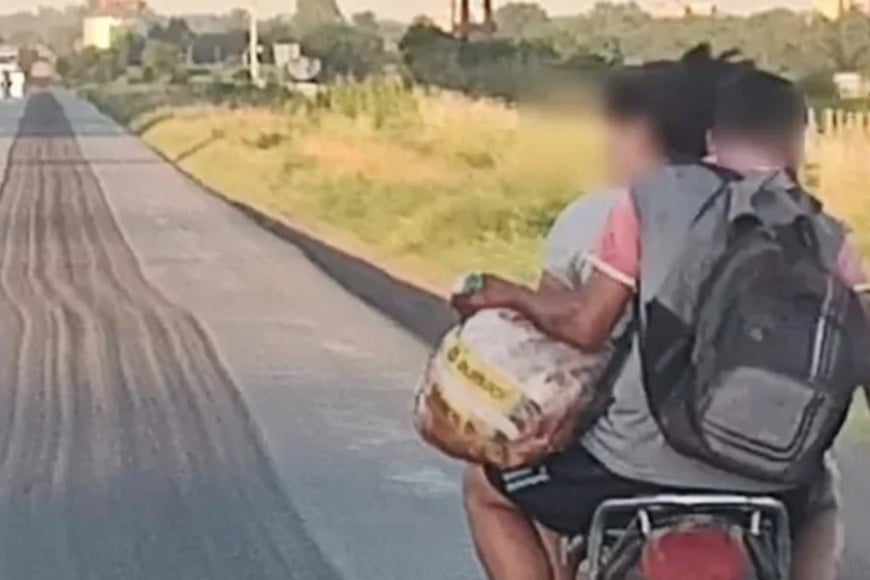 A bordo de una moto, dos jóvenes se llevan un gran trozo de carne recién faenada. Crédito: LA OPINION