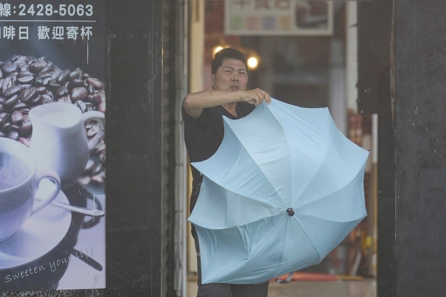 A man struggles with an umbrella, as Typhoon Kong-rey approaches in Keelung, Taiwan October 31, 2024. REUTERS/Walid Berrazeg