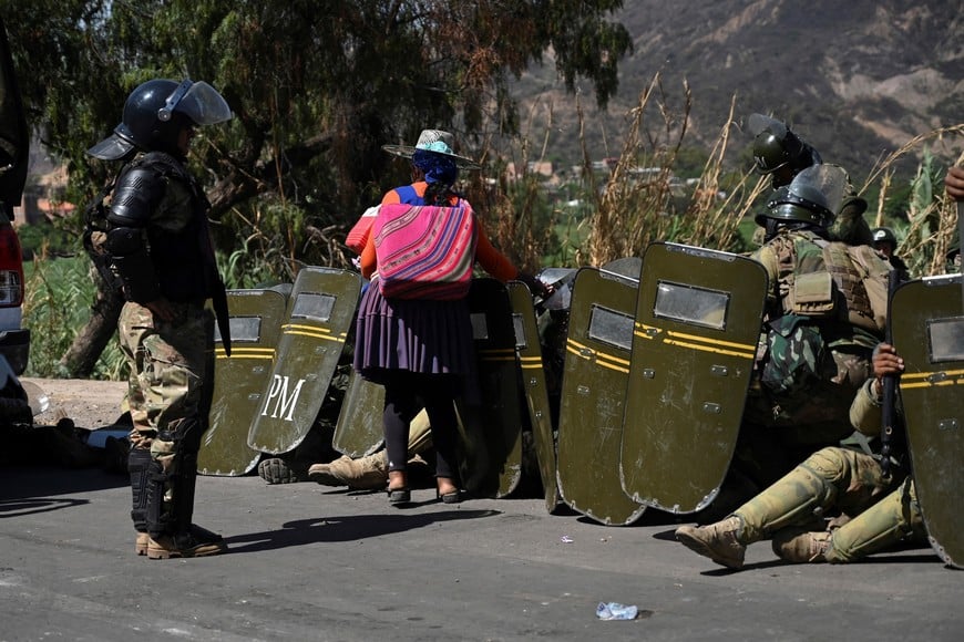 A woman sells ice cream to soldiers on guard as supporters of former President Evo Morales block key roads preventing the delivery of food and fuel, amid rising political tensions between a faction around Morales and the government of his former ally, President Luis Arce, in Parotani, Cochabamba, Bolivia November 1, 2024. REUTERS/Claudia Morales