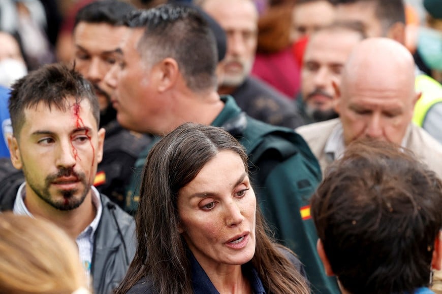 Spain's Queen Letizia speaks to people as she has mud on her face, following heavy rains that caused floods, in Paiporta, near Valencia, Spain, November 3, 2024. REUTERS/Eva Manez