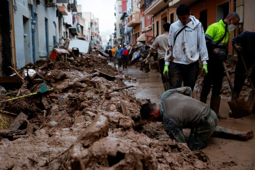 People help to clean, following heavy rains that caused floods, in Paiporta, near Valencia, Spain, November 4, 2024. REUTERS/Eva Manez