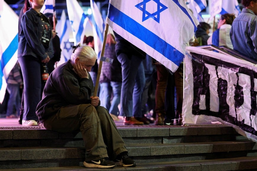 A demonstrator sits during a protest held by Israelis after Israeli Prime Minister Benjamin Netanyahu sacked his defense minister, Yoav Gallant, citing lack of trust, and against the PM's government, in Nahariya, Israel November 5, 2024. REUTERS/Violeta Santos Moura