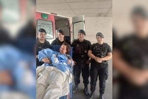 La feliz mamá, junto a su bebé, y los agentes que la ayudaron.