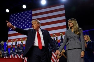 Republican presidential nominee and former U.S. President Donald Trump gestures as he holds hands with his wife Melania during his rally, at the Palm Beach County Convention Center in West Palm Beach, Florida, U.S., November 6, 2024. REUTERS/Brian Snyder     TPX IMAGES OF THE DAY