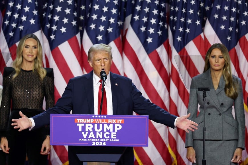 Republican presidential nominee and former U.S. President Donald Trump is flanked by Melania Trump and Lara Trump as he addresses supporters, during the 2024 U.S. Presidential Election, in Palm Beach County Convention Center, in West Palm Beach, Florida, U.S., November 6, 2024. REUTERS/Brendan Mcdermid