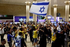 People celebrate as Maccabi Tel Aviv soccer fans arrive at the Ben Gurion International Airport, after overnight attacks after the match between Maccabi and Ajax Amsterdam, in Lod, Israel, November 8, 2024. REUTERS/Thomas Peter