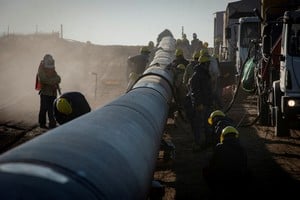 FILE PHOTO: Workers are pictured during the construction of the Nestor Kirchner gas pipeline, which first stage was inaugurated on Sunday to transport natural gas from the Vaca Muerta formation in western Argentina to the province of Santa Fe, passing through the province of Buenos Aires, in Macachin, La Pampa, Argentina April 26, 2023. REUTERS/Martin Cossarini NO RESALES. NO ARCHIVES/File Photo