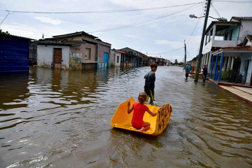 FILE PHOTO: Children play on a flooded street as Hurricane Milton passes close to the Cuban coast, in Batabano, Cuba, October 9, 2024. REUTERS/Norlys Perez/File Photo