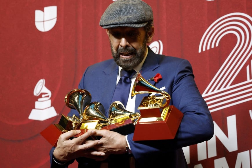 Juan Luis Guerra drops one of his awards as he poses with Best Tropical Song and Record Of The Year for "Mambo 23", and Best Album of the Year and Best merenguebachata album for Radio Guira, at the 25th Annual Latin Grammy Awards in Miami, Florida, U.S., November 14, 2024. REUTERS/Marco Bello     TPX IMAGES OF THE DAY