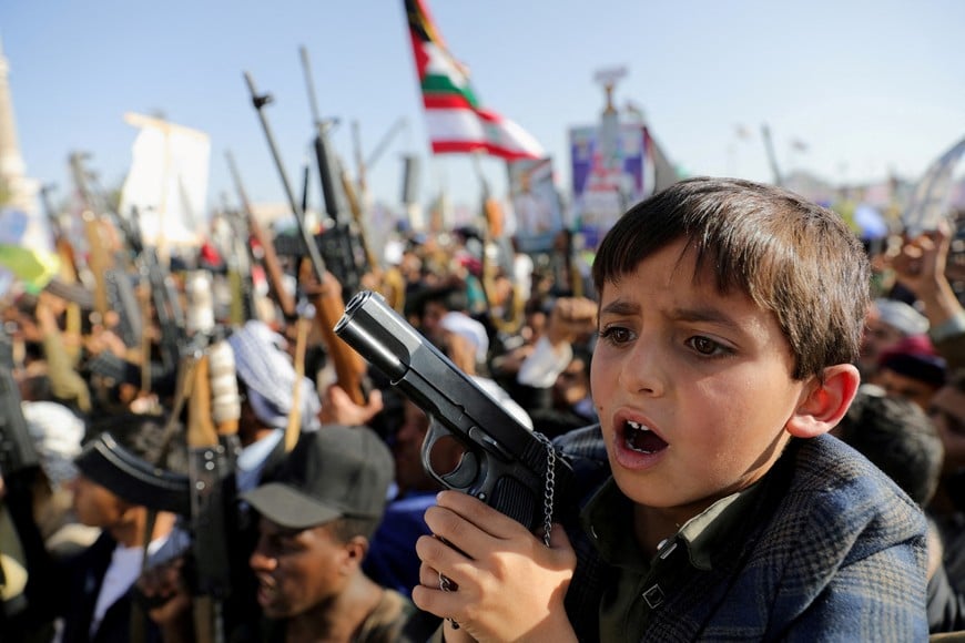 A boy holds a pistol as he joins protesters, predominantly Houthi supporters, during a rally in solidarity with Palestinians in the Gaza Strip and with Lebanon's Hezbollah, amid Israel's conflicts with Hamas and Hezbollah, in Sanaa, Yemen November 15, 2024. REUTERS/Khaled Abdullah     TPX IMAGES OF THE DAY