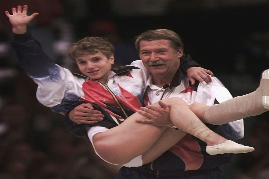 Lo que cuesta vale. El entrenador Bela Karolyi carga en brazos a la gimnasta estadounidense Kerri Strug para que reciba la medalla de oro en los Juegos Olímpicos de Atlanta 1996 luego de romperse los ligamentos de su tobillo.