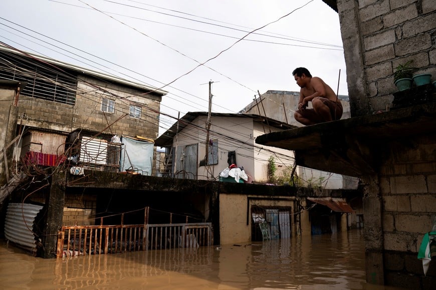 A man sits on a ledge outside his flooded house following super typhoon Man-Yi, in Cabanatuan, Nueva Ecija, Philippines, November 18, 2024. REUTERS/Lisa Marie David