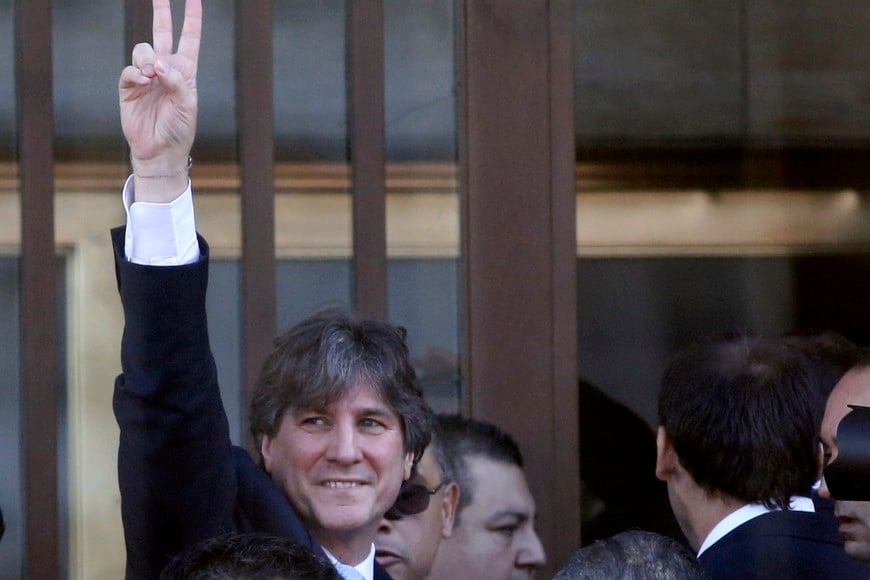 Argentina's Vice President Amado Boudou gestures to supporters as he arrives at a federal court in Buenos Aires June 9, 2014. Boudou received summons to appear in court over accusations of alleged irregularities in the purchase of the Ciccone Calcografica printing company while serving as economy minister. The investigation centres on whether Boudou helped the printing company get out of bankruptcy in 2010 and later steered a contract to its new owners to print money. REUTERS/Enrique Marcarian (ARGENTINA - Tags: CRIME LAW POLITICS) buenos aires amado boudou vicepresidente llega a comodoro py indagatoria indagatoria a vicepresidente por caso ciccone causa que investiga el rescate  de la ex Ciccone Calcografica