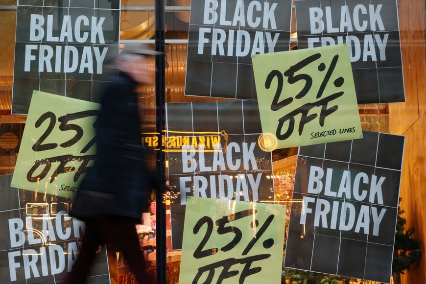 A shopper walks past Black Friday sale signs at a store on Oxford Street in London, Britain November 28, 2024. REUTERS/Hollie Adams