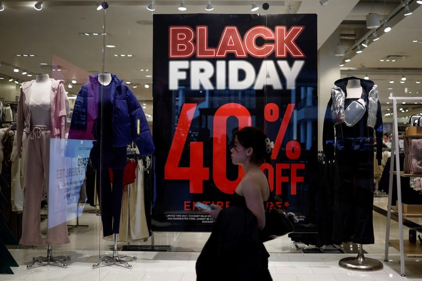 FILE PHOTO: A shopper walks past an advertisement for Black Friday sales displayed in a store window at Pentagon City in Arlington, Virginia, U.S., November 27, 2024. REUTERS/Benoit Tessier/File Photo