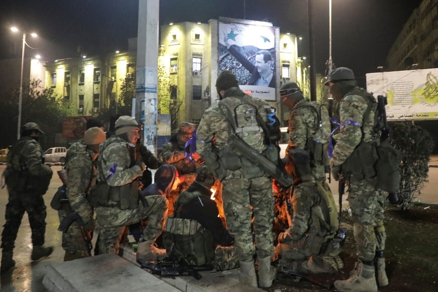 Syrian opposition fighters gather around a fire to keep themselves warm at Saadallah al-Jabiri Square, after rebels opposed to Syria's President Bashar al-Assad said they had reached the heart of Aleppo, Syria November 30, 2024. REUTERS/Mahmoud Hasano