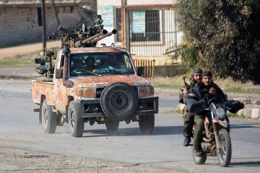 Rebels led by the Islamist militant group Hayat Tahrir al-Sham drive on a motorbike in al-Rashideen, Aleppo province, Syria November 29, 2024. REUTERS/Mahmoud Hasano