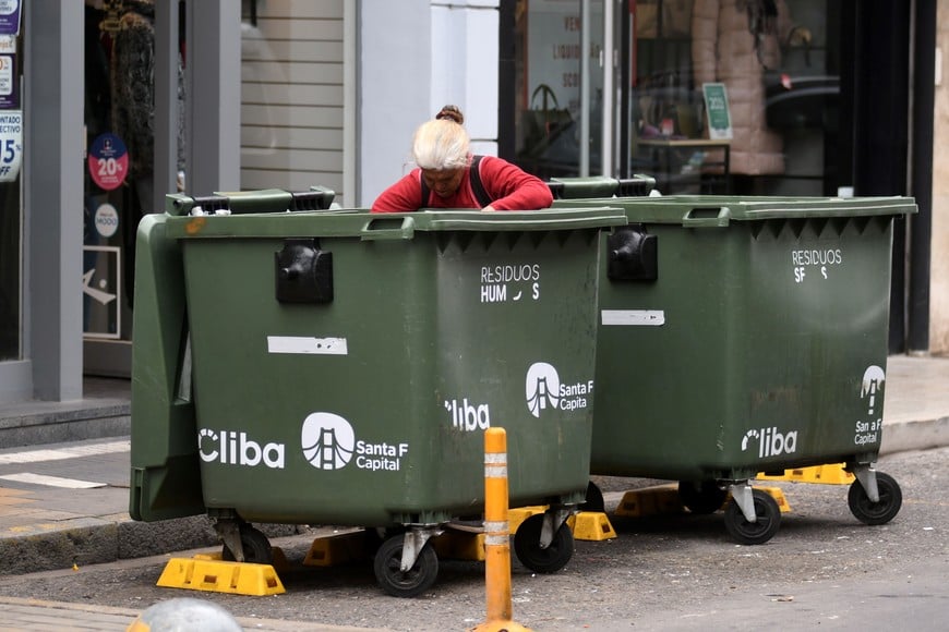 La foto que más duele. Una mujer revuelve la basura de un contenedor en busca de algo para comer.