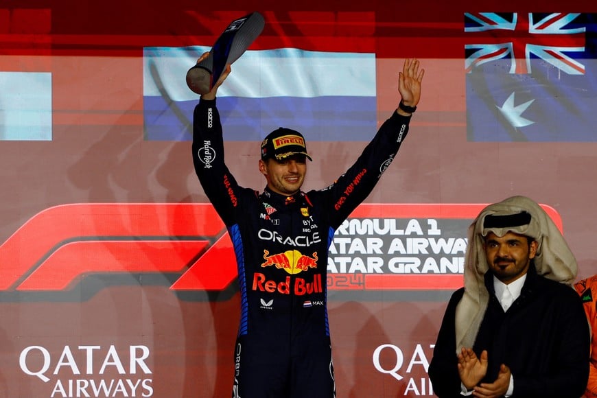 Formula One F1 - Qatar Grand Prix - Lusail International Circuit, Lusail, Qatar - December 1, 2024 
Red Bull's Max Verstappen celebrates with a trophy on the podium after winning the Qatar Grand Prix REUTERS/Rula Rouhana