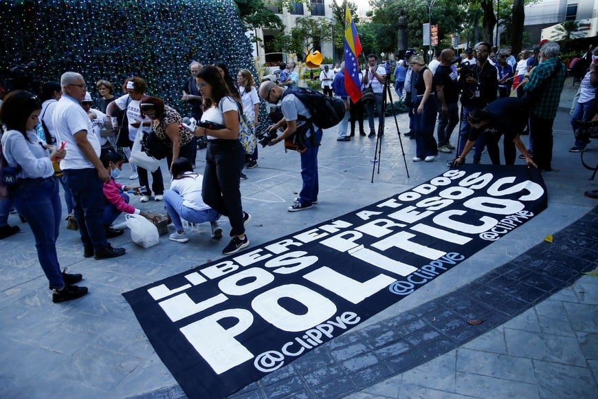 Supporters of Venezuela's opposition leader Maria Corina Machado gather at a protest against President Nicolas Maduro and in support of people who were detained during protests challenging the presidential election results, displaying a banner that reads, "release all political prisoners", in front of a church in Caracas, Venezuela December 1, 2024. REUTERS/Leonardo Fernandez Viloria