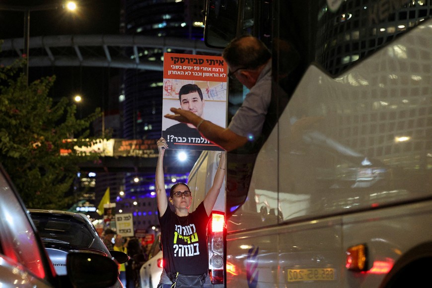 FILE PHOTO: A demonstrator holds a sign in the middle of traffic with the image of hostage Itay Svirsky, kidnapped during the deadly October 7, 2023 attack by Hamas and later killed, during a protest to demand a ceasefire deal and the immediate release of hostages, in Tel Aviv, Israel, October 27, 2024. REUTERS/Violeta Santos Moura/File Photo