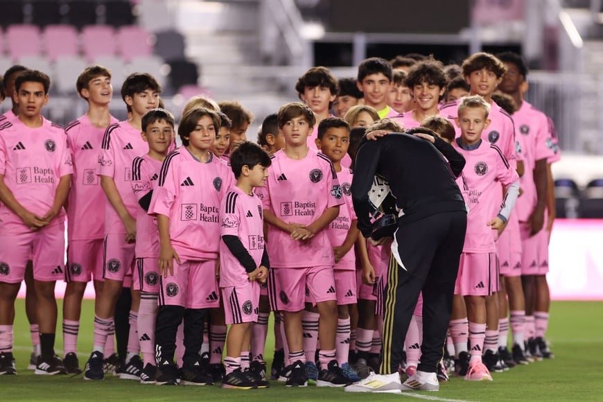 Dec 4, 2024; Ft. Lauderdale, Florida, USA; Inter Miami CF forward Lionel Messi (10) hugs his son Mateo Messi after receiving the Landon Donovan MVP Award trophy from Thiago Messi (center) and Ciro Messi (left) during a presentation ceremony at Chase Stadium. Mandatory Credit: Sam Navarro-Imagn Images