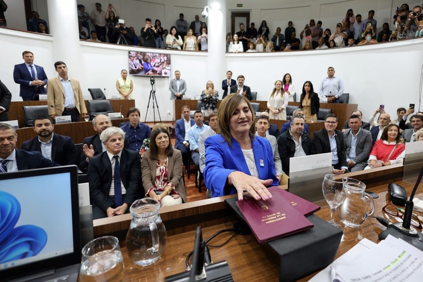 El momento de la jura. La acompañan el secretario administrativo y la secretaria legislativa del Cuerpo.