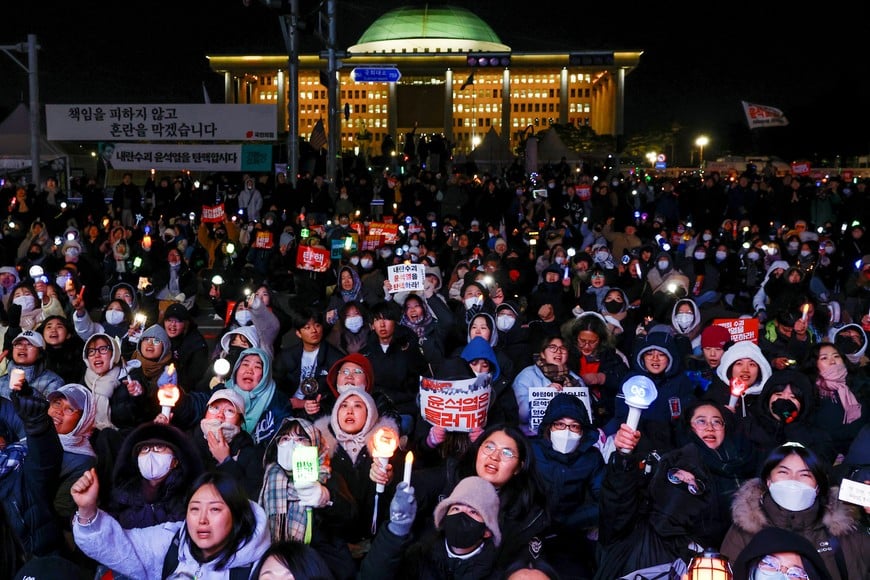 Protesters react after South Korean President Yoon Suk Yeol, who declared martial law which was reversed hours later, survived an impeachment motion, in front of the National Assembly in Seoul, South Korea, December 7, 2024. REUTERS/Kim Kyung-Hoon     TPX IMAGES OF THE DAY