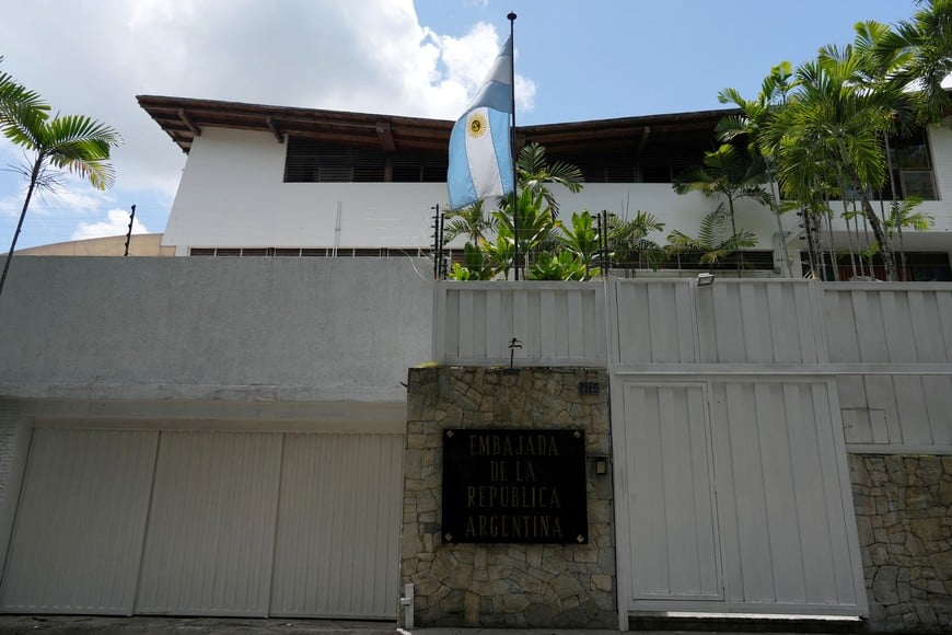 The Argentinian flag is raised, after lowering the Brazilian flag, at the Argentine embassy, where Venezuelan opposition members have sought asylum since March, after Argentine diplomats were expelled from Venezuela, in Caracas, Venezuela August 1, 2024. REUTERS/Alexandre Meneghini