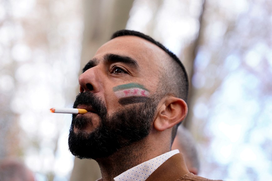 A person with a Syrian opposition flag painted on their face attends a protest celebrating the fall of Bashar Al-Assad's regime outside the Syrian embassy in Madrid, Spain, December 8, 2024. REUTERS/Ana Beltran