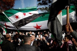 People hold Syrian opposition flags as they celebrate in Lafayette Square outside the White House, after Syrian rebels announced that they have ousted President Bashar al-Assad, in Washington, U.S., December 8, 2024. REUTERS/Benoit Tessier