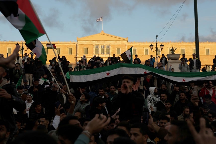 Syrians living in Greece gather in Syntagma square after Syrian rebels announced that they have ousted President Bashar al-Assad in Syria, in Athens, Greece, December 8, 2024. REUTERS/Louiza Vradi