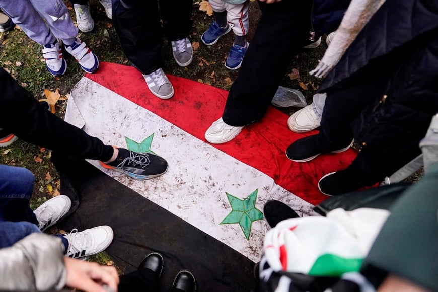 People step on the Syria government's flag during a protest celebrating the fall of Bashar Al-Assad’s regime outside the Syrian embassy in Madrid, Spain, December 8, 2024. REUTERS/Ana Beltran