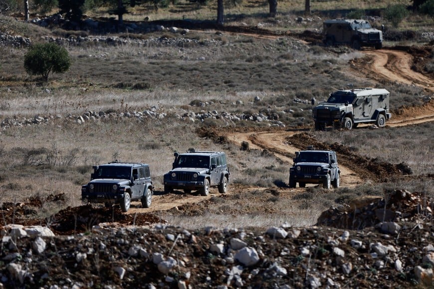 Israeli soldiers ride in military vehicles as they gather near the ceasefire line between Syria and the Israeli-occupied Golan Heights, December 9, 2024. REUTERS/Ammar Awad