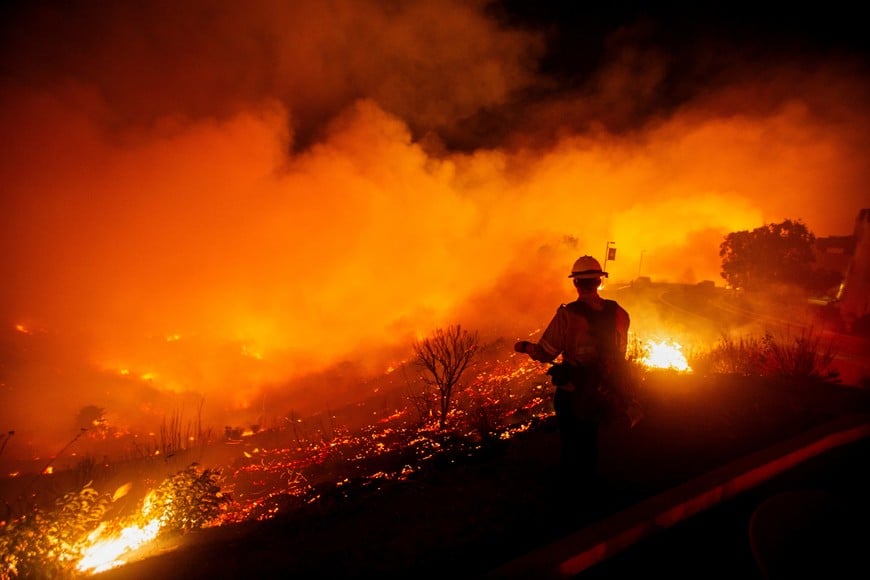 A firefighter watches as the Franklin Fire burns in Malibu, California, U.S., December 10, 2024. REUTERS/Ringo Chiu