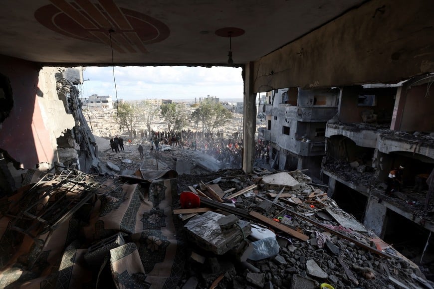 Palestinians inspect the damage at the site of an Israeli strike, amid the Israel-Hamas conflict, at the Nuseirat refugee camp in the central Gaza Strip, December 13, 2024. REUTERS/Ramadan Abed