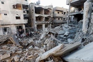 Palestinians inspect the damage at the site of an Israeli strike, amid the Israel-Hamas conflict, at the Nuseirat refugee camp in the central Gaza Strip, December 13, 2024. REUTERS/Ramadan Abed