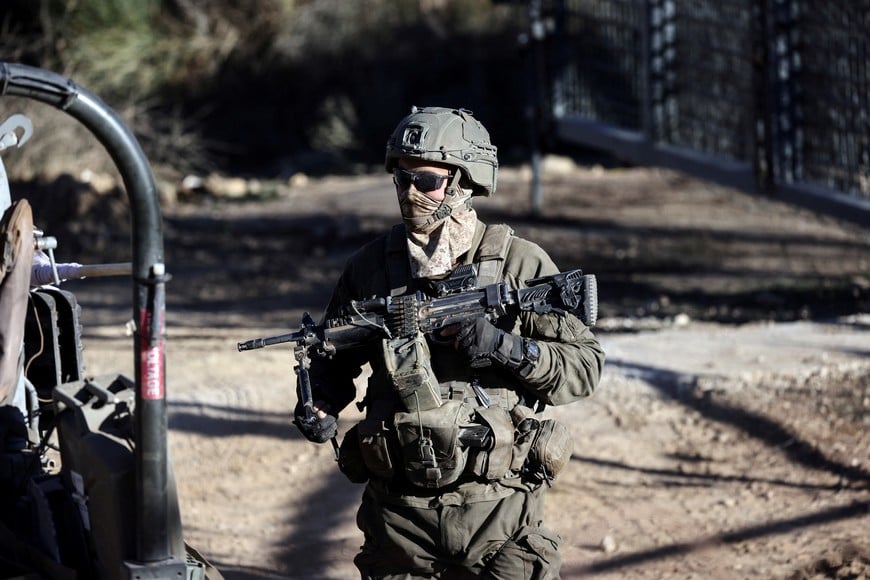 An Israeli soldier stands by the ceasefire line between the Israeli-occupied Golan Heights and Syria, as seen from Majdal Shams in the Golan Heights, December 15, 2024. REUTERS/Jamal Awad