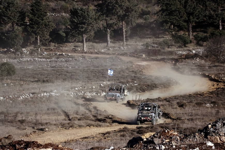 Israeli military vehicles ride through Syria close to the ceasefire line between the Israeli-occupied Golan Heights and Syria, as seen from Majdal Shams in the Golan Heights, December 15, 2024. REUTERS/Jamal Awad