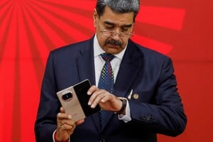 Venezuela's President Nicolas Maduro looks at his watch while holding his mobile phone on the other hand as he attends a meeting of leaders of the member states of the Bolivarian Alliance for the Peoples of Our America and the Treaty of Commerce and Promotion (ALBA-TCP), in Caracas, Venezuela December 14, 2024. REUTERS/Leonardo Fernandez Viloria