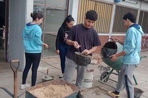 Estudiantes de la institución, en el frente de la escuela, ayudando con la colocación de losetas recicladas de su invención.
Foto: El Litoral