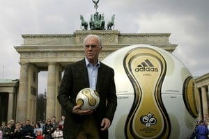 FILE PHOTO: Franz Beckenbauer, President of Germany's World Cup organising committee, holds a golden soccer ball during a presentation next to the Brandenburg gate in Berlin, Germany April 18, 2006. REUTERS/Tobias Schwarz/File Photo