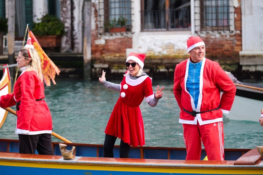 People dressed as Santa Claus attend a Christmas regatta along the Grand Canal in Venice, Italy, December 22, 2024. REUTERS/Manuel Silvestri