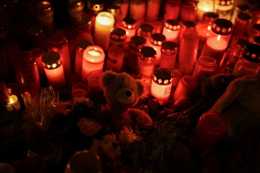 Candles burn, which were left as a tribute to the victims of 'Alter Markt' Christmas market, where a man drove a car into the crowd through an emergency exit route on Friday evening, in Magdeburg, Germany, December 22, 2024.  REUTERS/Annegret Hilse