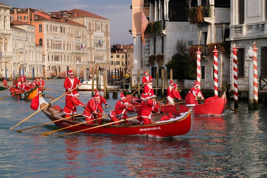 People dressed as Santa Claus row during a Christmas regatta along the Grand Canal in Venice, Italy, December 22, 2024. REUTERS/Manuel Silvestri