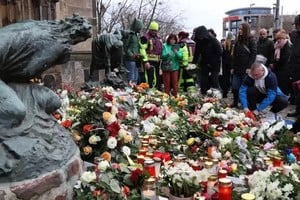 Cientos de personas depositan ofrendas en el frontis de la iglesia de San Juan. Ronny Hartmann/AFP/DW