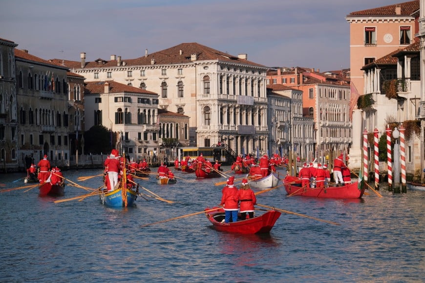 People dressed as Santa Claus row during a Christmas regatta along the Grand Canal in Venice, Italy, December 22, 2024. REUTERS/Manuel Silvestri