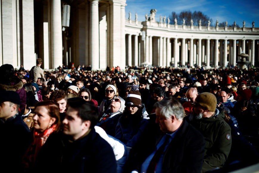 People wait for Pope Francis to deliver his traditional Christmas Day Urbi et Orbi speech to the city and the world from the main balcony of St. Peter's Basilica at the Vatican, December 25, 2024. REUTERS/Yara Nardi