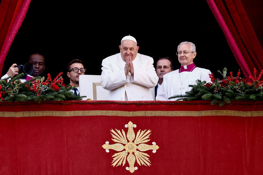 Pope Francis gestures on the day he delivers his traditional Christmas Day Urbi et Orbi speech to the city and the world from the main balcony of St. Peter's Basilica at the Vatican, December 25, 2024. REUTERS/Yara Nardi