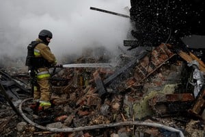 A firefighter works at the site of residential buildings hit by a Russian drone strike, amid Russia's attack on Ukraine, in Kharkiv, Ukraine December 25, 2024. REUTERS/Sofiia Gatilova     TPX IMAGES OF THE DAY